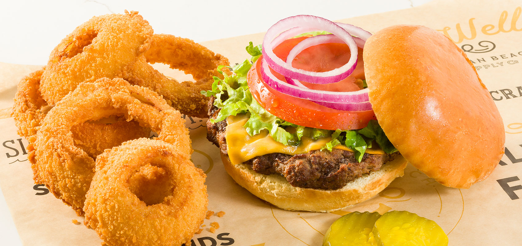 Onion rings and burger with a slice of cheese, onions and beef pattytomato