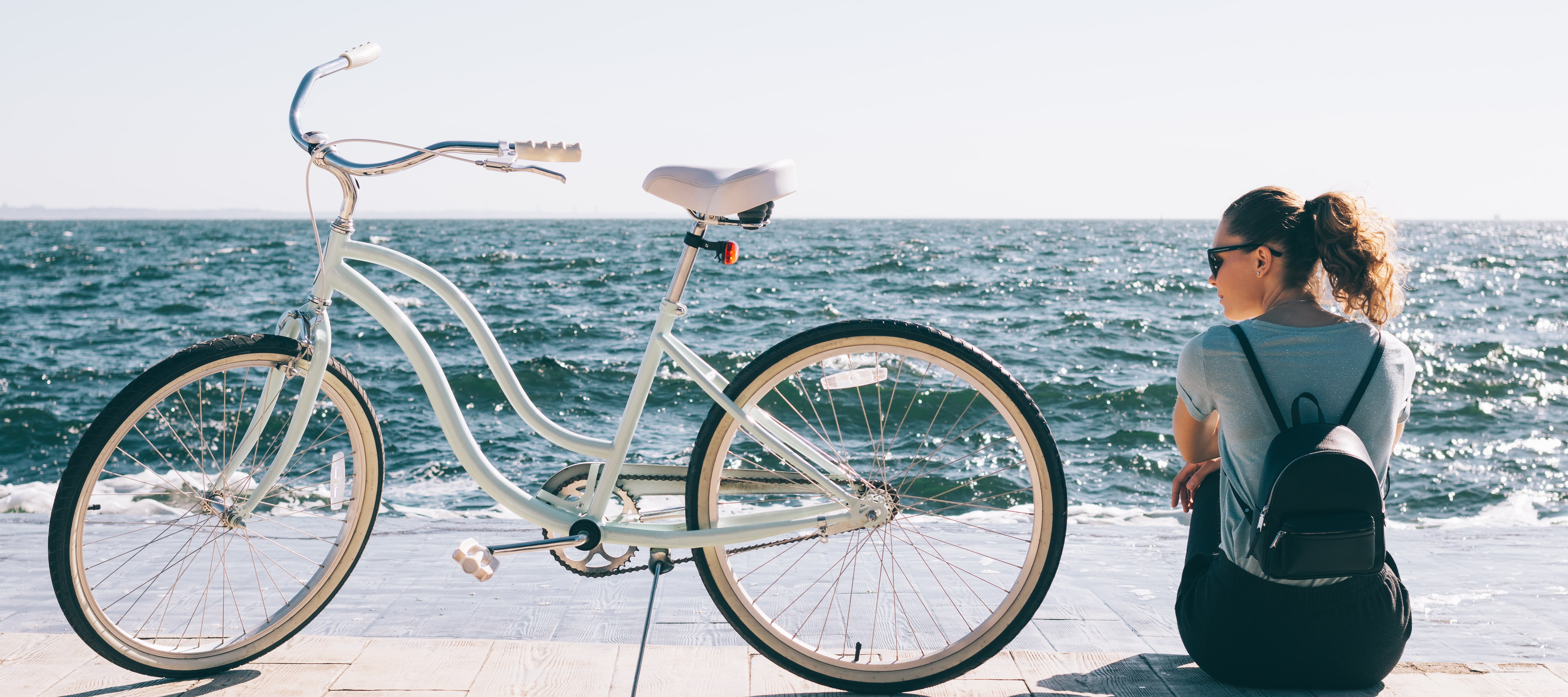 girl with a bicycle by a lake