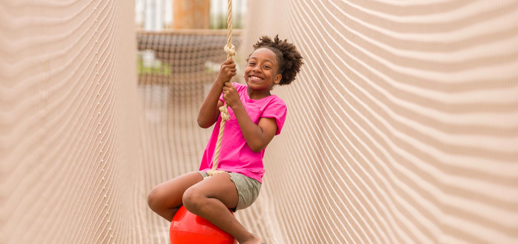 Happy girl riding on rope swing