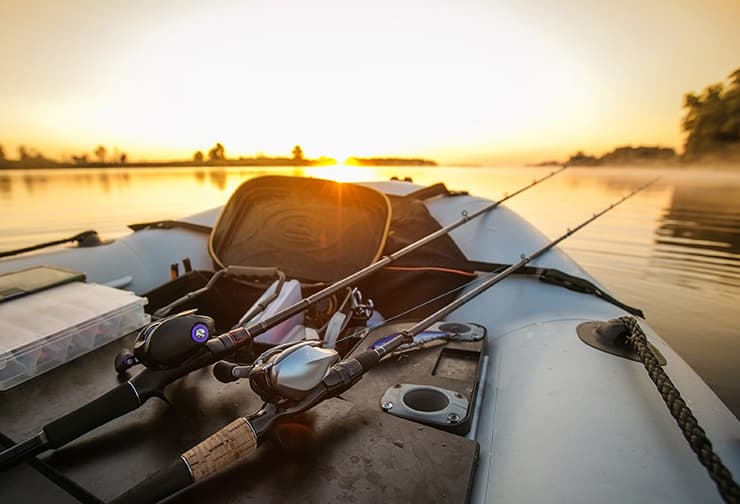 two fishing rods leaning against a white cooler on a boat