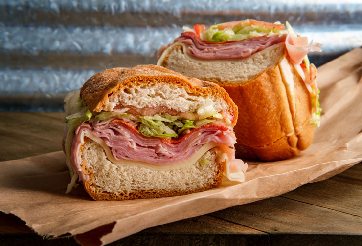 a sandwich cut in half on a white paper plate