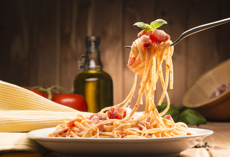 a plate of spaghetti being eaten with a fork.