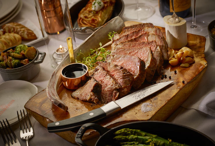 a cooked and sliced steak on a cutting board, ready to be eaten.