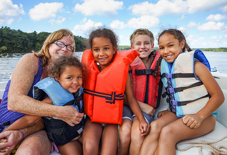 family of five posing for a picture on a pontoon boat