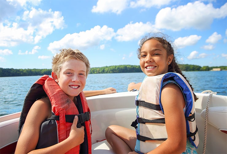 two smiling kids on a boat