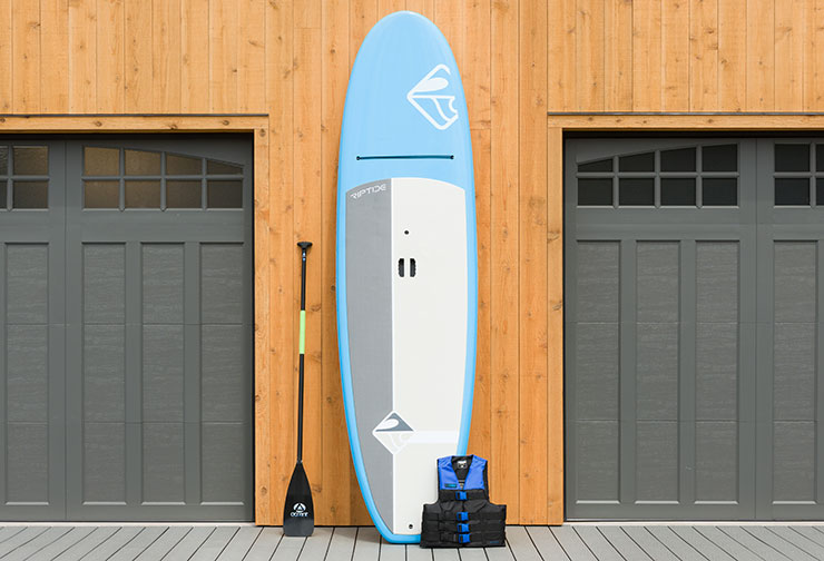 Blue Paddle board with a paddle and life jacket at the deck