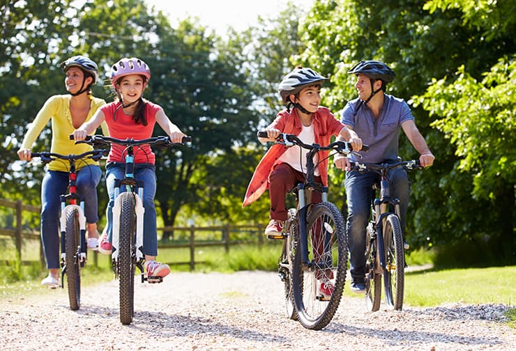family of four enjoy biking together