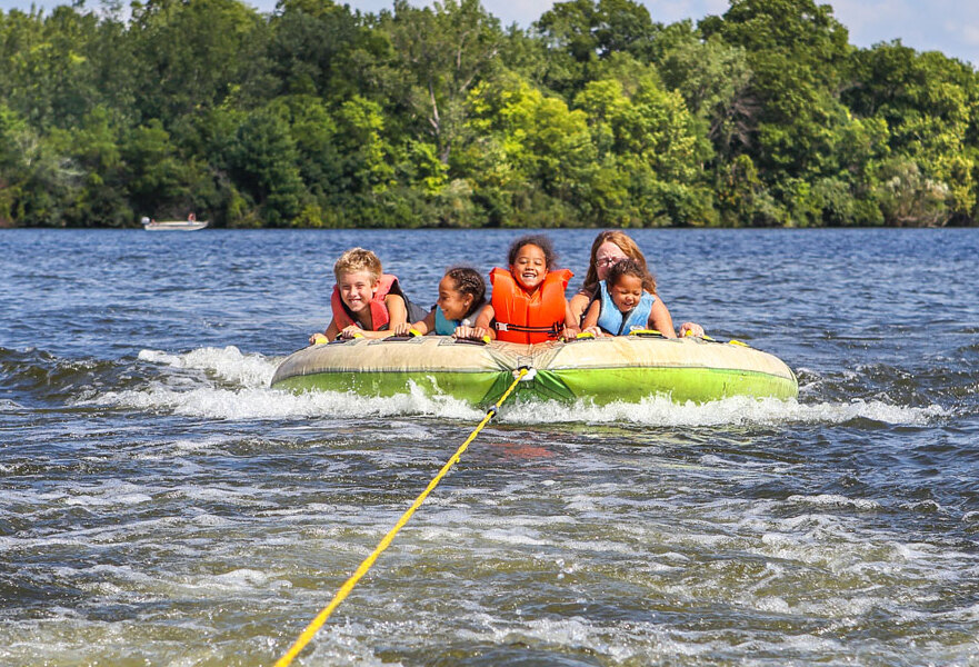 kids on a tube hooked to a boat in the lake