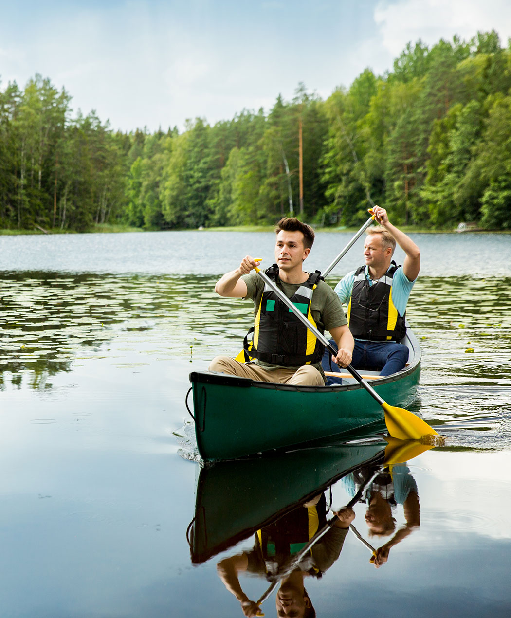 Red canoe with two paddles and two life jackets on a deck