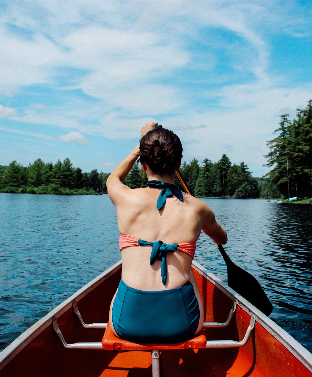 woman paddling canoe on a summer day