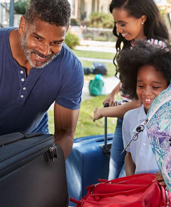Family putting luggage in car