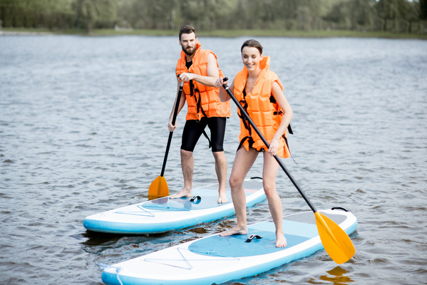 Man And Woman Paddle Boarding